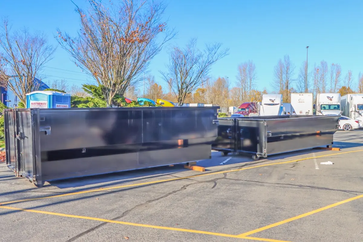 Professional dumpster rental service with roll-off container on residential driveway in East Donegal